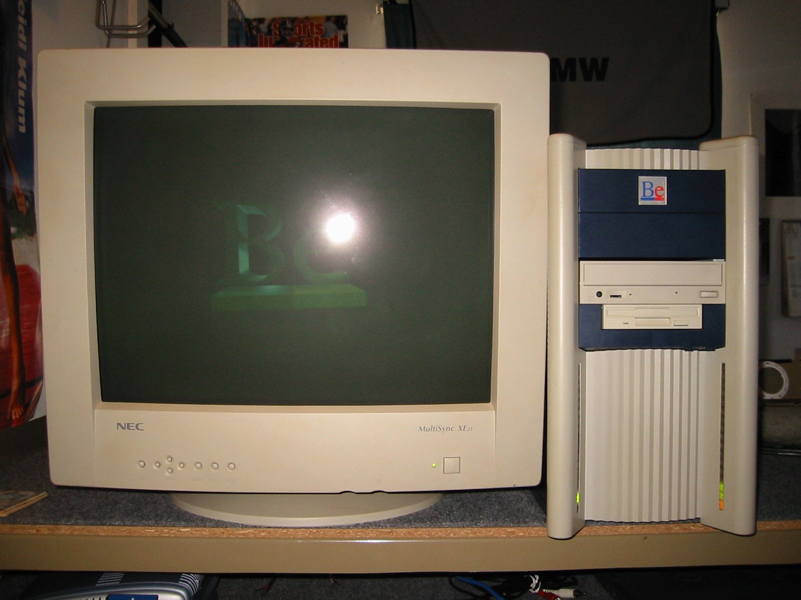 BeBox running BeOS with the green Be 3D splash on an NEC MultiSync XE21 monitor, the BeBox tower with Blinkenlights glowing on the case, late-2001 desk setup